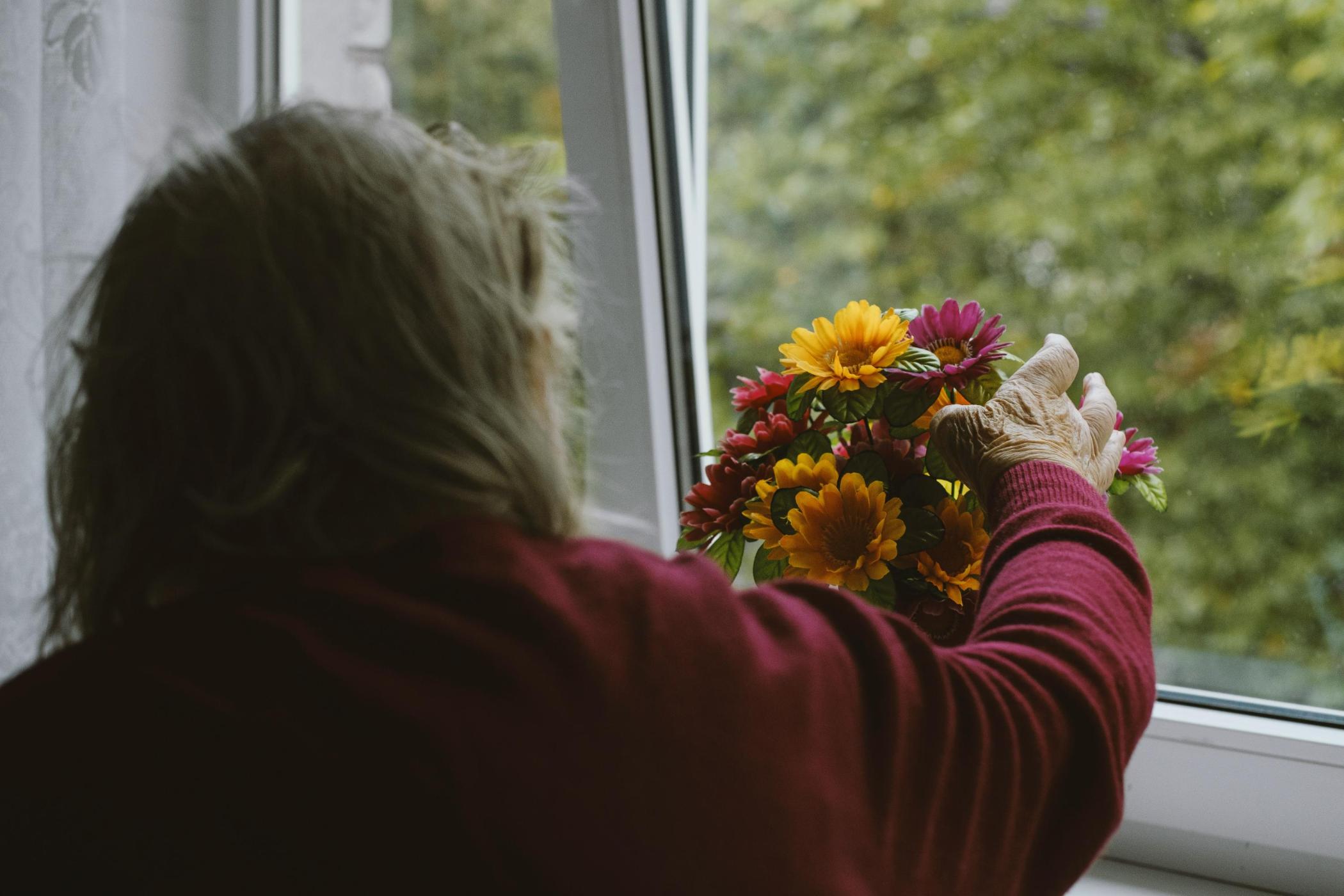 woman-with-flowers-by-a-window