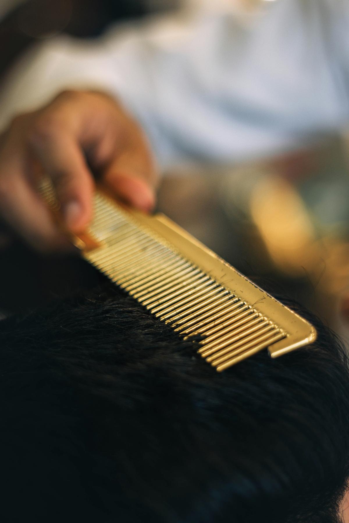 close-up-of-man-combing-someones-hair
