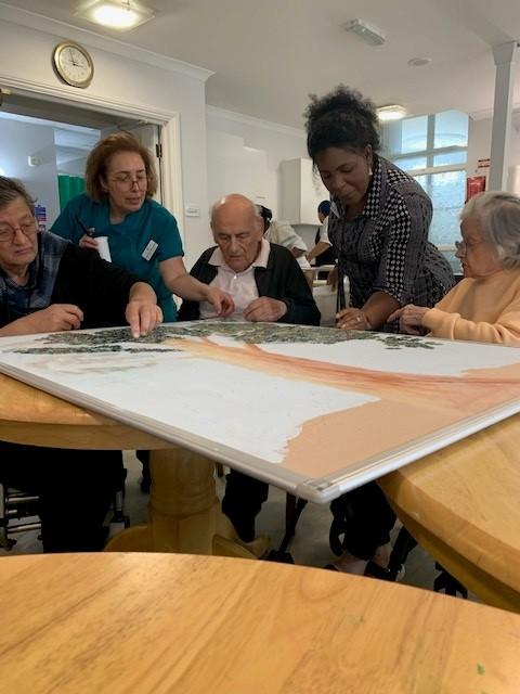 staff and residents using jigsaw puzzle pieces to create art