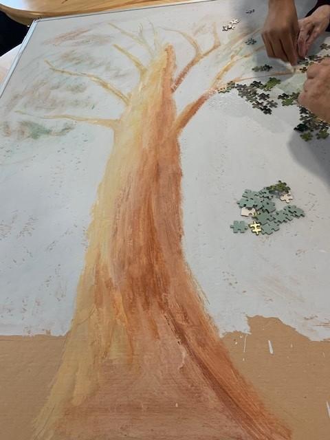 staff and residents using jigsaw puzzle pieces to create art