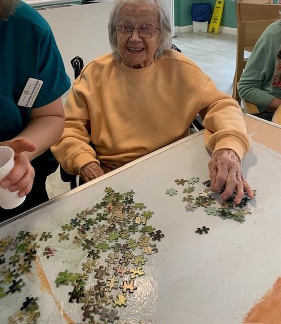 staff and residents using jigsaw puzzle pieces to create art