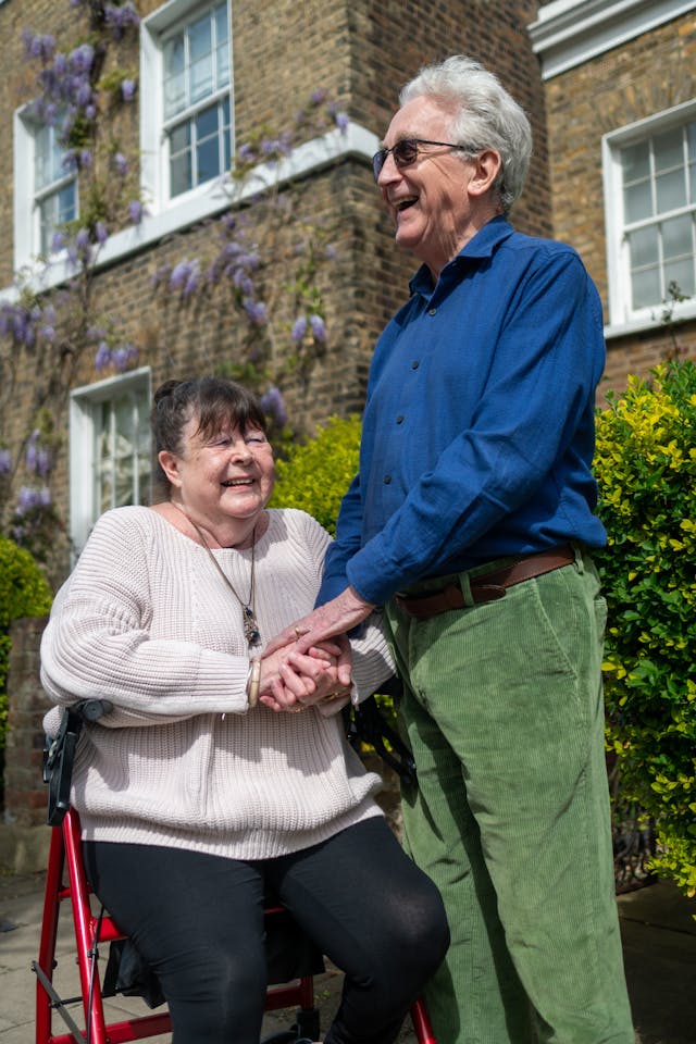 elderly couple with a walking aid in a garden