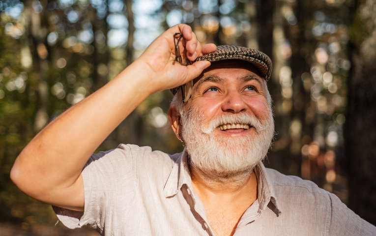 older man with a peak hat smiling