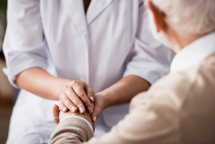 carer and resident holding hands